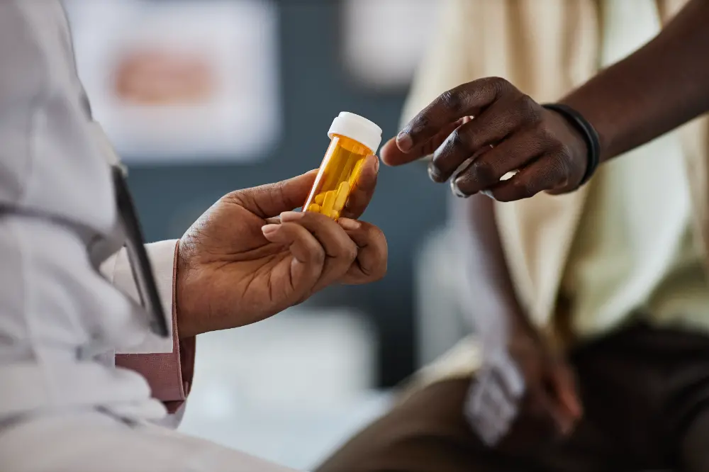 Black doctor giving pills to patient